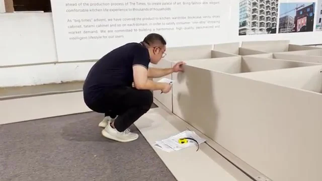 Technician inspecting a cabinet assembly during a recorded cabinetry production and quality-check process