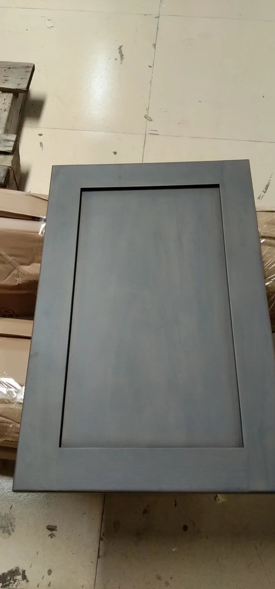 Dark gray stained cabinet door photographed in the workshop